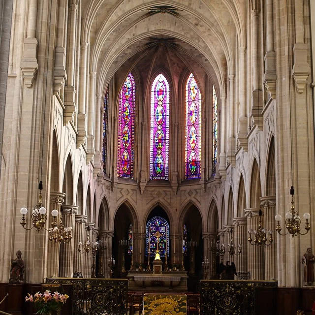 Soaring stone arches and stained glass inside a cathedral