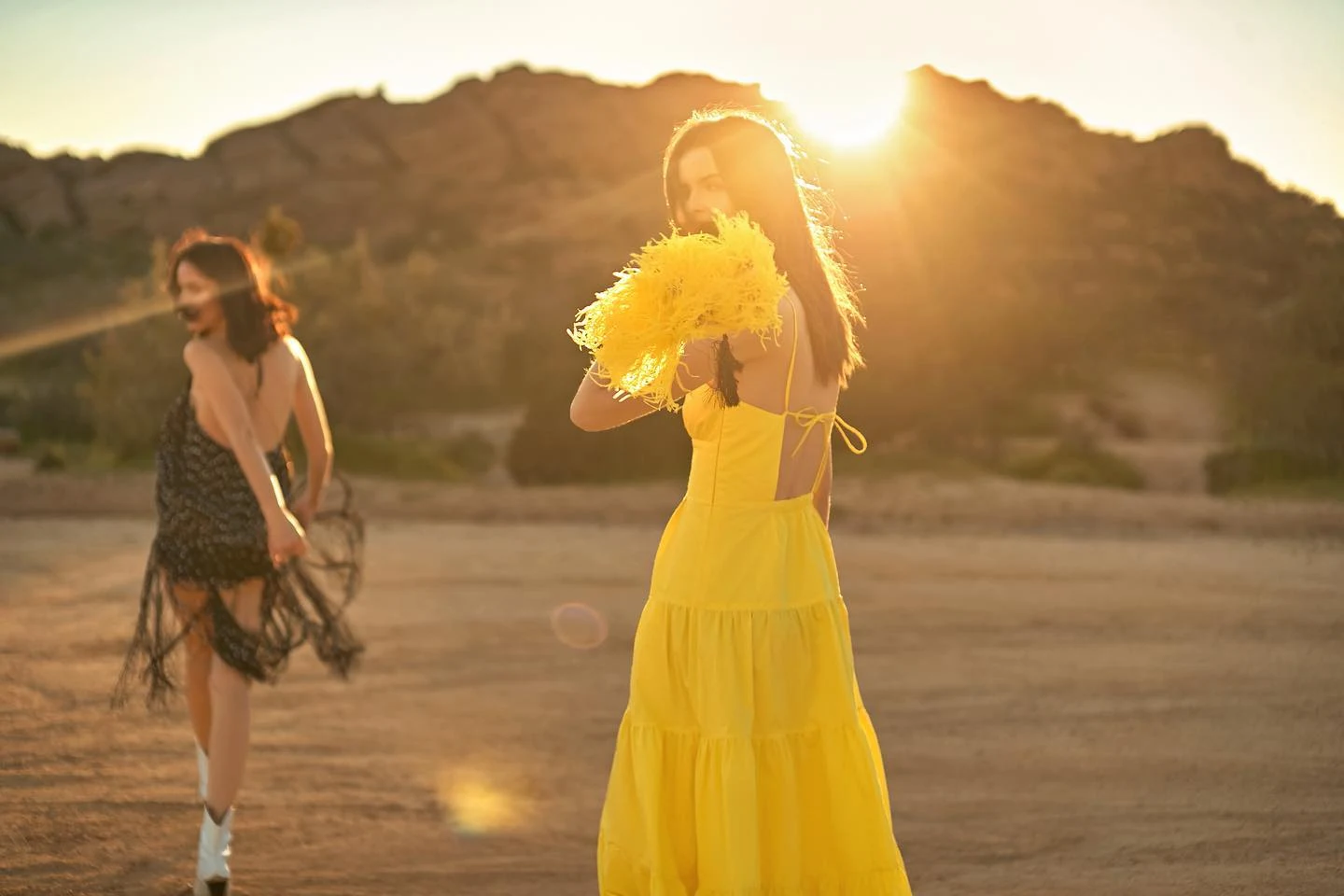 Two women in flowing dresses in the golden evening light