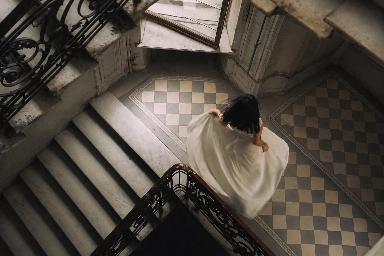 An overhead view of a woman descending a curved staircase