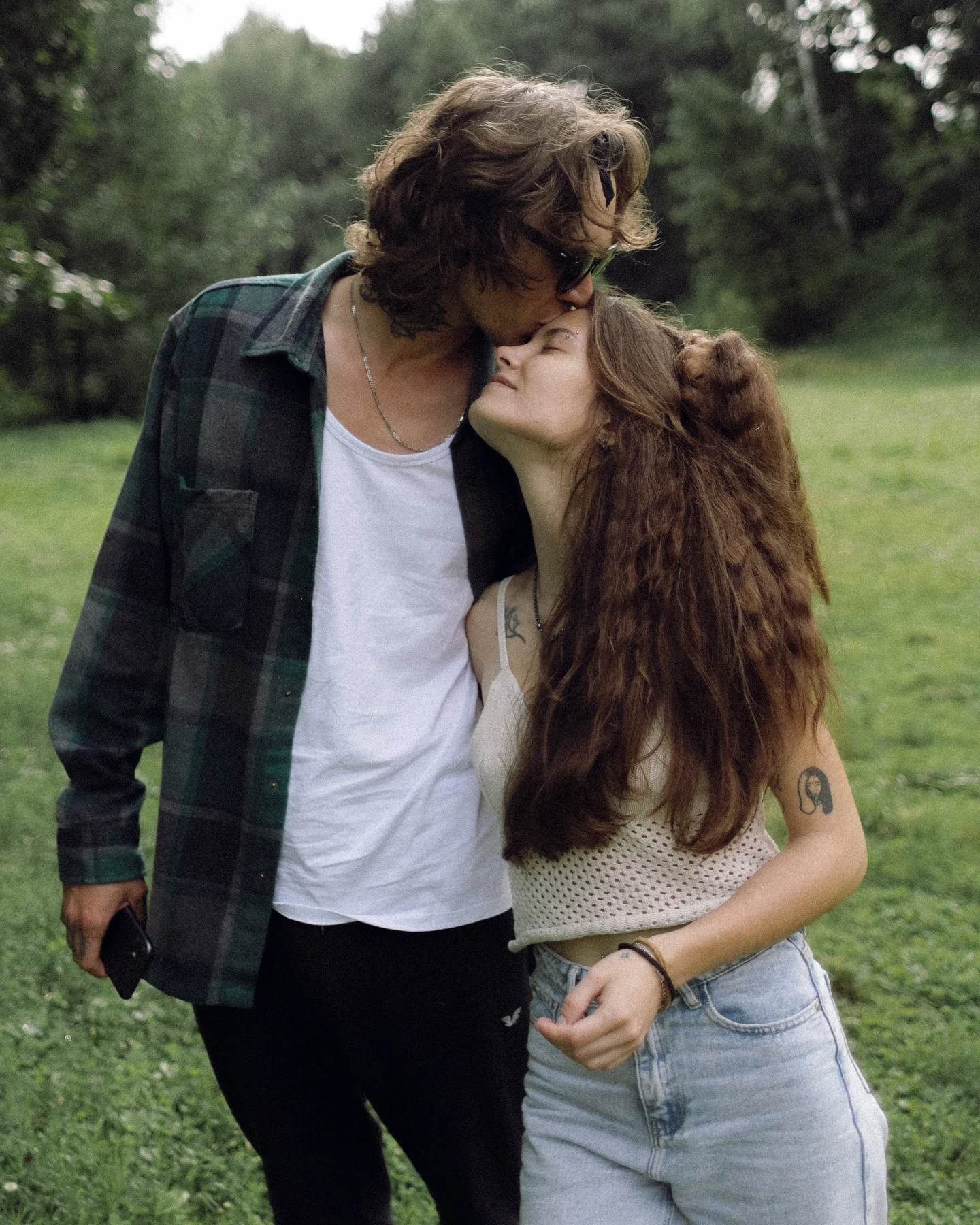 A couple sharing an affectionate kiss in a garden